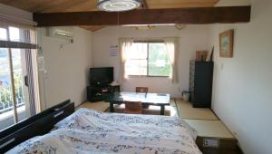 鐮倉的住宿－鎌倉民宿，一间卧室配有一张床、一张桌子和一个窗户。