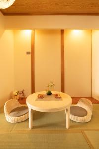 a living room with a table and two chairs at Bijou Suites Will in Osaka