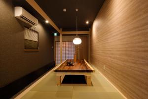a hallway with a wooden table in a room at Bijou Suites Will in Osaka