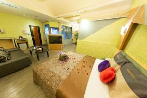 um quarto com uma cama e uma sala de estar em Giyoche Motel em Wanli
