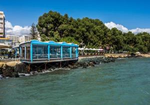 a blue train on a bridge over a river at Metro Court Apartments in Limassol