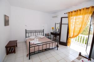 a bedroom with a bed and a desk and a window at Kefalonia Beach Hotel & Bungalows in Lixouri