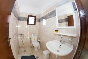 a bathroom with a sink and a toilet at Kefalonia Beach Hotel & Bungalows in Lixouri
