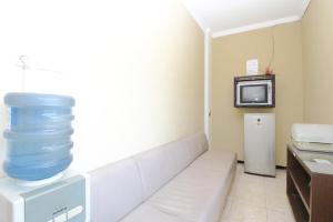 a room with a couch with a bowl on top of it at RedDoorz Near PRPP Marina Semarang in Kalibanteng-lor