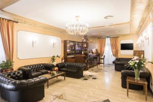 a living room with leather furniture and a chandelier at Hotel Villa Rosa in Rome