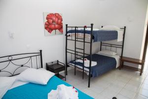 a room with two beds and a bunk bed at Kefalonia Beach Hotel & Bungalows in Lixouri