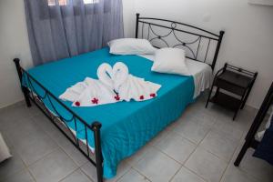 a bedroom with a bed with two swans towels at Kefalonia Beach Hotel & Bungalows in Lixouri