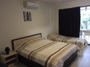 two beds in a bedroom with a table and a window at The White Houses Complex in Nesebar