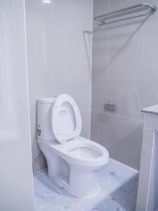 a white bathroom with a toilet and a shower at The Royal P Phuket - SHA Plus in Phuket Town