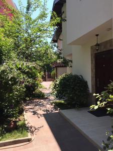 a walkway leading to a building with trees and a door at The White Houses Complex in Nesebar