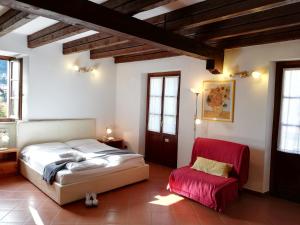 a bedroom with a bed and a red chair at Casa Cannobio in Cannobio