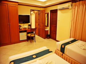 1 dormitorio con 2 camas y escritorio con ordenador en Baan SS Karon, en Karon Beach