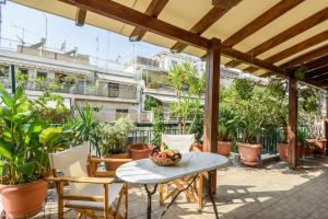 a patio with a table and chairs and plants at Sophie's Penthouse in Athens in Athens