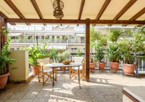 a patio with a table and chairs and potted plants at Sophie's Penthouse in Athens in Athens