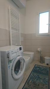 una lavadora en un baño con inodoro en casa olmo, en Caorle