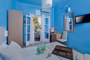 Habitación azul con cama y baño. en Poseidon Beach Hotel, en Kamari