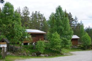 a cabin in the woods next to a road at Visit Wilderness in Åmli