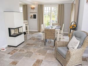 a living room with a fireplace and a dining room at Reethus Reddevitz mit Kamin, Sauna, Terrasse, Boddenblick in Alt Reddevitz