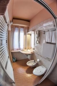 a bathroom with two sinks and a mirror at Hotel Angelini in Rimini