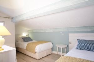 a bedroom with two beds and a table with a stool at Le Mas des Citronniers in Collioure