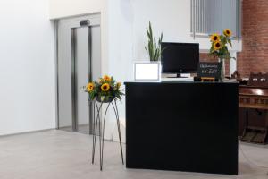 an office with a desk with a computer and sunflowers at EC-Hostel in Vaasa