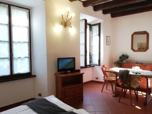 a living room with a television and a dining room table at Casa Cannobio in Cannobio