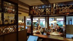 a group of people sitting at tables in a restaurant at Hotel im Ferienpark Retgendorf in Retgendorf