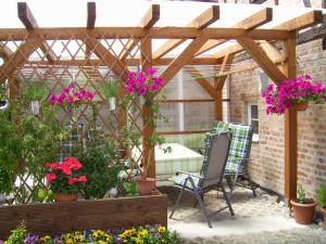 a patio with flowers and a wooden pergola at Ferien-/ Monteurwohnung Nette in Themar