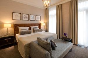 a bedroom with a large bed and a chair at Steigenberger Icon Parkhotel Düsseldorf in Düsseldorf