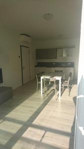 a dining room with a white table and chairs at casa olmo in Caorle