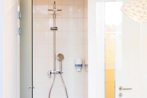 un bagno con doccia e porta in vetro di Maverick City Lodge a Budapest