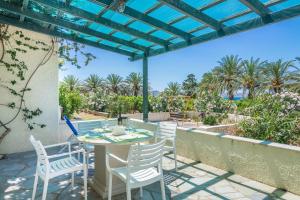 a table and chairs on a patio with a view of the ocean at Jasmine house in Sitia