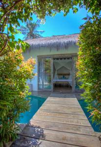 dom z basenem i drewnianym chodnikiem w obiekcie Atoll Haven Villas w Gili Air