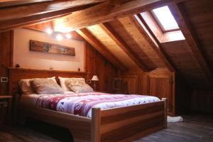 アオスタにあるMaison D'Antan Alloggio ad uso turistico VDA CHARVENSOD n 0022の木製の天井の客室で、ベッドルーム1室(ベッド1台付)