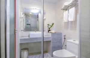 a bathroom with a toilet, sink and tub at Triton Beach Hotel & Spa in Maafushi