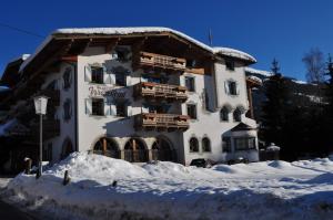un grand bâtiment avec de la neige devant lui dans l'établissement Hotel Wiesenegg, à Aurach bei Kitzbuhel
