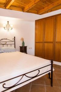 a bedroom with a large bed and a wooden cabinet at Agrilos Οlive Τree Αpartment in Mirsíni