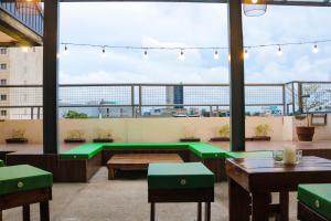 a rooftop patio with tables and benches and a view of the city at RedDoorz @ Junquera Extension Cebu in Cebu City