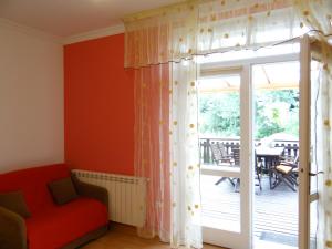 a living room with a red chair and a sliding glass door at Dom na wzgórzu in Gorlice