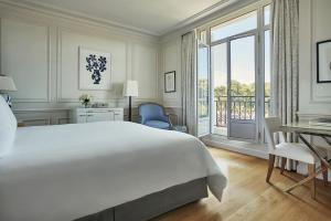 a bedroom with a large white bed and a balcony at Grand-Hôtel du Cap-Ferrat, A Four Seasons Hotel in Saint-Jean-Cap-Ferrat