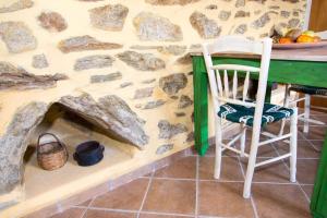 a room with a stone wall with a table and a chair at Agrilos Οlive Τree Αpartment in Mirsíni