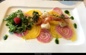 un plato blanco de comida con cebolla y ensalada en Gasthaus Knudsen, en Utersum