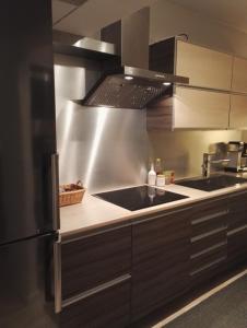 eine Küche mit einer Spüle und einem Kühlschrank in der Unterkunft Peaceful City Centre Apartment (2 Bdr) in Rovaniemi
