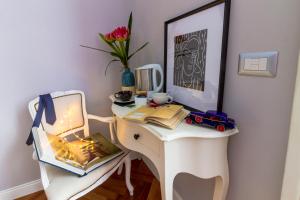 a white desk with a chair and a table with a computer at Athena Guest House in Rome
