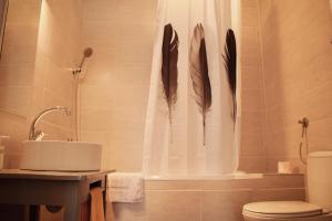 a bathroom with a shower with feathers on the shower curtain at Studio apartment LoSt in Ogulin