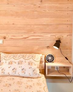 a bedroom with a wooden wall with a bed and a lamp at Studio apartment LoSt in Ogulin