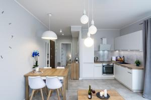 a kitchen and living room with a table and chairs at Elite Apartments Family City Center in Gdańsk