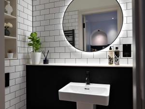 a white sink sitting under a mirror in a bathroom at Student Castle - Studio Apartments in Bath