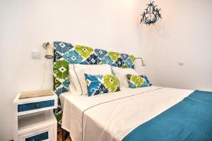 a bedroom with a bed with blue and green pillows at Blue Barqueta Studio in Faro