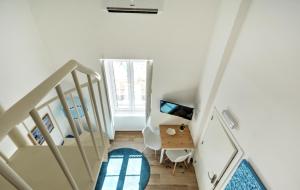a white room with a staircase and a desk at Blue Barqueta Studio in Faro